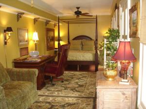 a living room with a bed and a desk and a couch at 22 Charlotte in Charleston