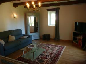 a living room with a blue couch and a glass table at Domaine de Marsaguettes in Morlhon-le-Haut