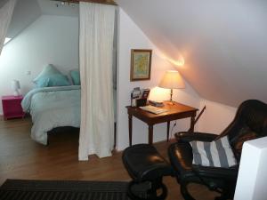 a bedroom with a bed and a desk and a chair at Domaine de Marsaguettes in Morlhon-le-Haut