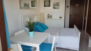 アルヴォルにあるApartamento Praia do Alvorの白いテーブルと椅子、白いテーブルと青い枕
