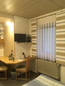 een kamer met een bureau en een raam bij Pension Haus Wanninger in Warmensteinach