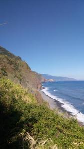 uma vista para a praia a partir de uma colina com o oceano em Casa Reis em Santana