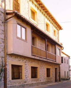 a building with a balcony on the side of it at Casa Granero in Rascafría