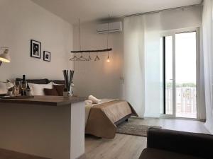 a bedroom with a bed and a large window at VIATOREM Suites in Torre dell'Orso
