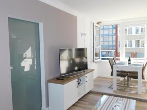 a living room with a flat screen tv on a cabinet at Nordsee in Nordstrand