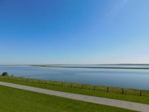 a view of a large body of water with a sidewalk at Nordsee in Nordstrand