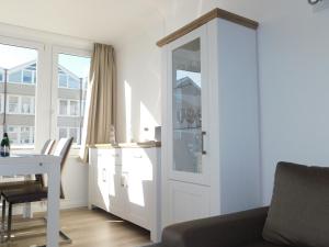 a living room with a white door and a table at Nordsee in Nordstrand