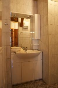 ein Bad mit einem Waschbecken und einem Spiegel in der Unterkunft Holzblockhäuser Fam. Schabus in Hermagor