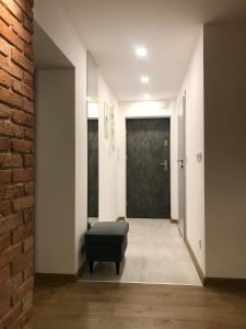 korytarz z czarną otomanką przed drzwiami w obiekcie Apartament 45M2 Czeladz 8Km Do Katowic w mieście Czeladź