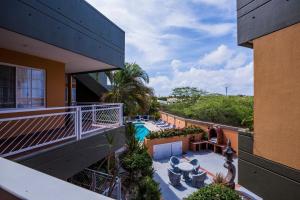 an apartment balcony with a pool and patio furniture at King David Suites in Palm-Eagle Beach
