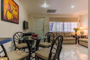 a living room with a table and chairs and a couch at King David Suites in Palm-Eagle Beach