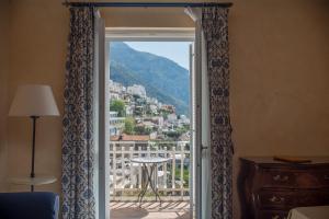 a room with a window with a view of a city at Hotel Posa Posa in Positano