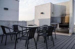 stół i krzesła na balkonie z kominkiem w obiekcie Austral Rentahome Nueva Providencia w mieście Santiago