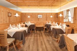 a dining room with tables and chairs and wooden walls at Das Mitterplarser Hotel in Lagundo