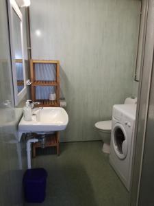 a bathroom with a sink and a washing machine at Kaikanten Kro og Rorbu in Sennesvik