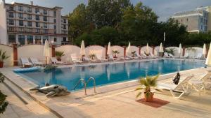 a large swimming pool with chairs and a dolphin in it at Cantilena Complex in Sunny Beach