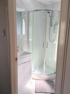 a white bathroom with a shower and a sink at 24 Old Scapa Road in Kirkwall