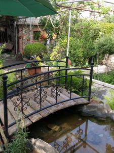 a bridge over a pond in a garden at Tamar Guest House in Gori