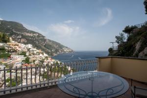 una mesa de cristal en un balcón con vistas al océano en Hotel Posa Posa, en Positano