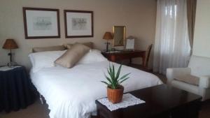 a bedroom with a large white bed and a table at Haus Schaaf b&b in Walvis Bay