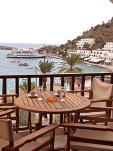 a dining room table with chairs and umbrellas at Villa Niki in Loutro