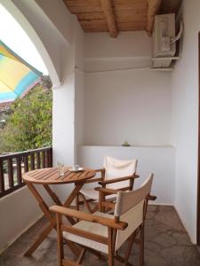 een tafel en stoelen op het balkon van een huis bij Villa Niki in Loutro