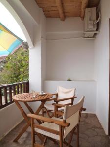 a patio area with a table, chairs, and a window at Villa Niki in Loutro
