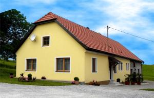 uma casa amarela com um telhado vermelho em Gästehaus zur alten Buche em Eisengraberamt