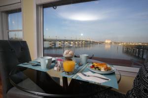 a table with a plate of food and a view of a harbor at Edgewater Inn - St. Augustine in St. Augustine