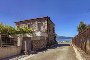 a building on the side of a road next to the water at Ianos Maisonette in Paralía Sergoúlas