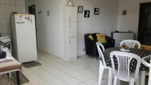 a kitchen with a table and chairs and a refrigerator at Beira mar Mariluz in Imbé