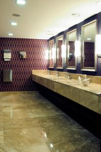 a bathroom with three sinks and three mirrors at Demora Hotel in Ankara