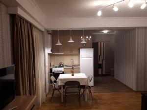 a kitchen with a white table and chairs in a room at Busas Apartment in Tbilisi City