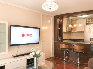 sala de estar con TV de pantalla plana en la pared en Kennedy Dream Apartment, en Santiago