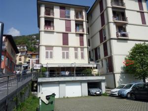 a tall building with cars parked in front of it at Appartamento FIORE in Cannero Riviera