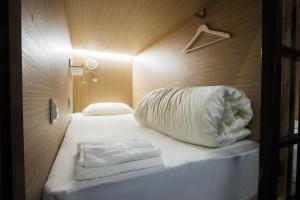 Buran capsule hotel في موسكو: غرفة نوم بسرير ذو شراشف ووسائد بيضاء