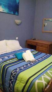 een slaapkamer met een bed met een blauwe en groene deken bij Residencial Moeda in Coimbra