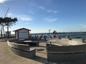 a pier with tables and benches next to the water at Fe-Wo im Dänemarkweg in Niendorf