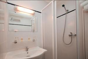 a white bathroom with a sink and a shower at Sky Hotel Goussainville Charles de Gaulle in Goussainville +19 photos