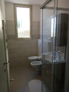 a bathroom with a toilet and a sink and a window at Appartamento FIORE in Cannero Riviera +26 photos