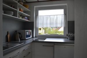 a kitchen with a window and a counter with a microwave at Chalupa Hanuliak in Terchová
