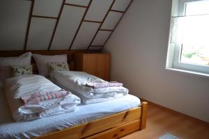 a bedroom with a bed with white pillows and a window at Chalupa Hanuliak in Terchová