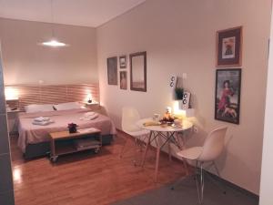 um quarto com uma cama, uma mesa e cadeiras em Koukaki ideal studio for 2 em Atenas