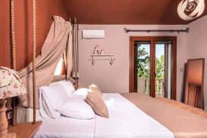 a bedroom with a canopy bed with white pillows at Fokas Luxury Villa in Prinos +118 photos