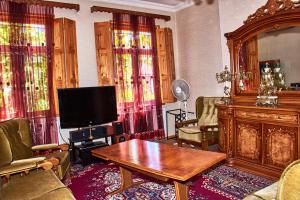 - un salon avec une télévision et une table en bois dans l'établissement Guest House Svetlana, à Gori