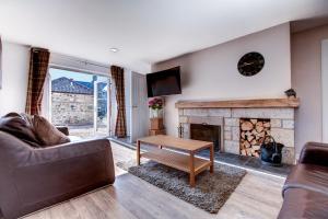 sala de estar con sofá y chimenea en Taylor Cottage en St Andrews