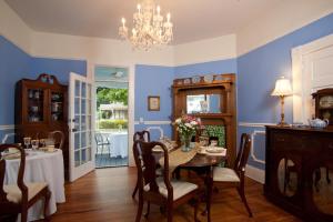 a dining room with a table and chairs and a chandelier at Blue Heron Inn in Fernandina Beach