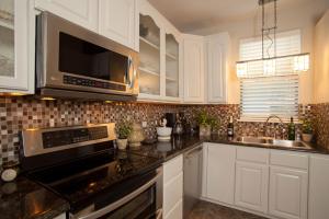a kitchen with white cabinets and a black counter top at Blue Heron Inn in Fernandina Beach