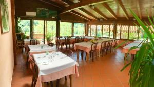 a dining room with tables and chairs and windows at Locanda Da Marco in Pignone