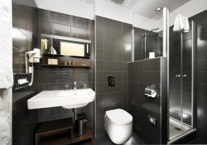 a bathroom with a toilet, sink, and shower at Opera Garden Hotel & Apartments in Budapest